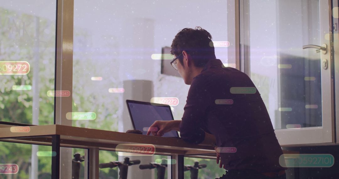 Man Working on Laptop with Data Visualization Overlay
