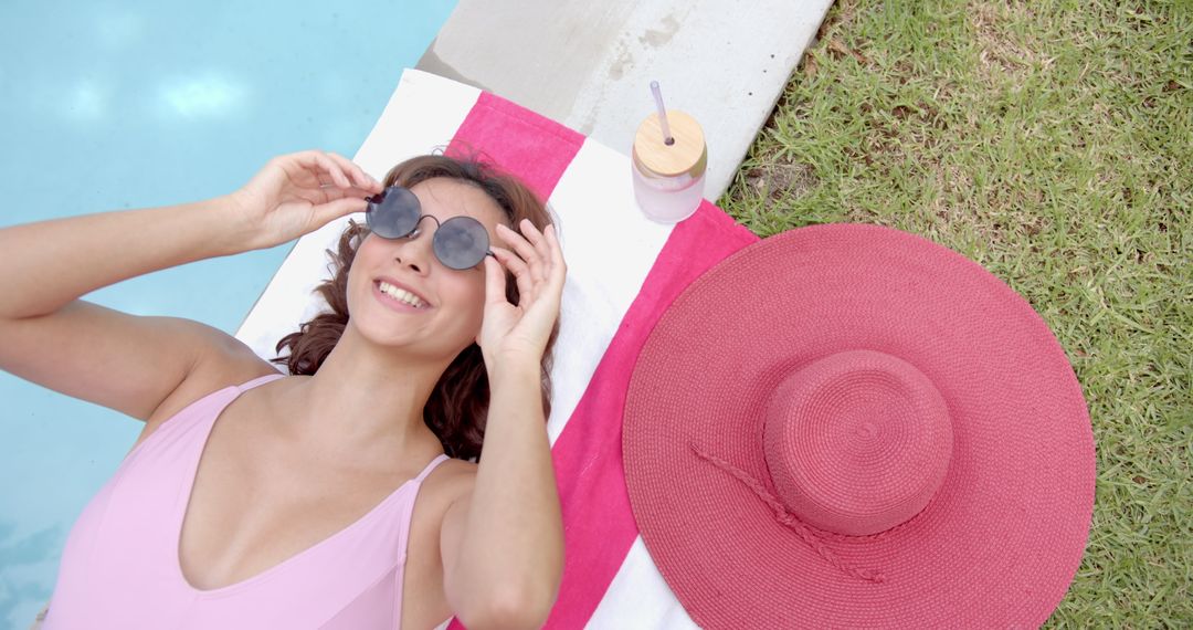 Woman Relaxing by Pool with Sunglasses and Pink Swimsuit