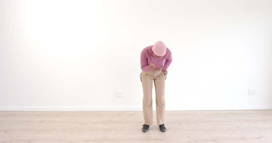 Elegant Woman Bowing in Minimalist Studio Setting