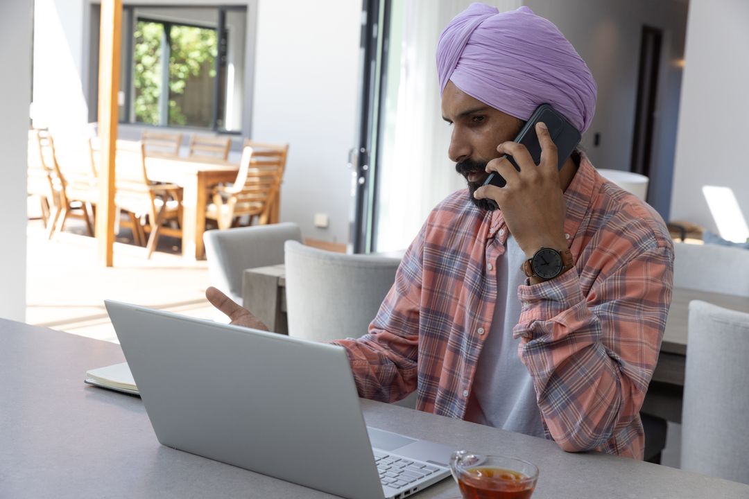 Professional Man in Turban Using Smartphone at Modern Workspace
