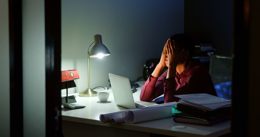 Stressed Office Worker Sitting at Desk Late at Night Covering Face with Hands - Free Images, Stock Photos and Pictures on Pikwizard.com