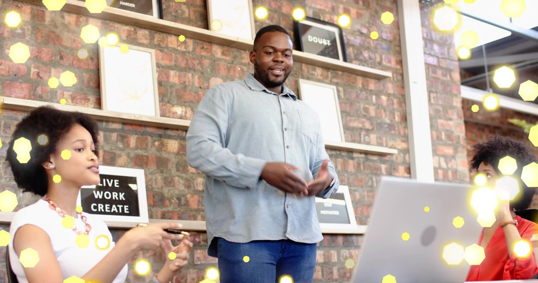 Presenter leading team brainstorming in modern industrial coworking space with laptop