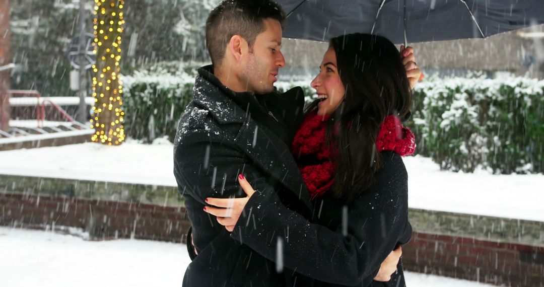 Couple Embracing Under Umbrella in Winter Wonderland - Free Images, Stock Photos and Pictures on Pikwizard.com