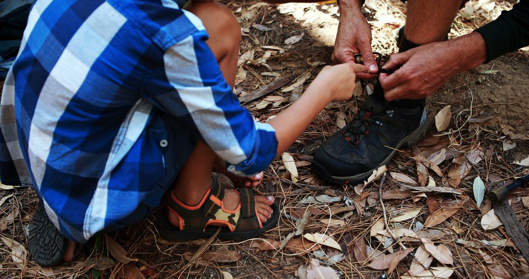 Child Helping Adult Tie Hiking Boots in Forest - Free Images, Stock Photos and Pictures on Pikwizard.com