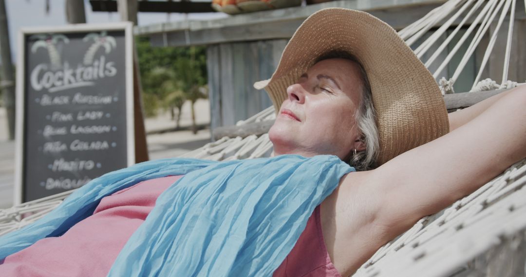 Elderly Woman Relaxing on Hammock at Tropical Beach Bar - Free Images, Stock Photos and Pictures on Pikwizard.com