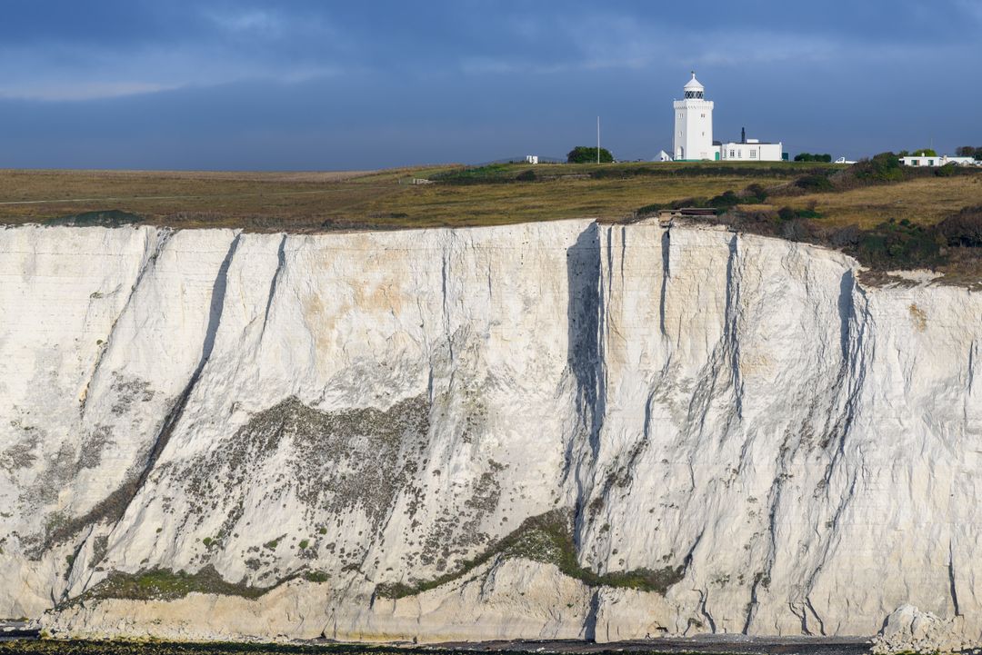 Scenic Lighthouse on Chalky Cliffs Overlooking Blue Sea