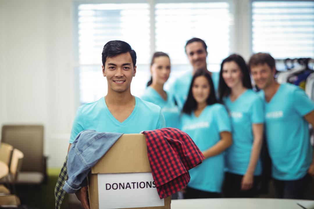 Volunteer holding clothes in donation box - Free Images, Stock Photos and Pictures on Pikwizard.com
