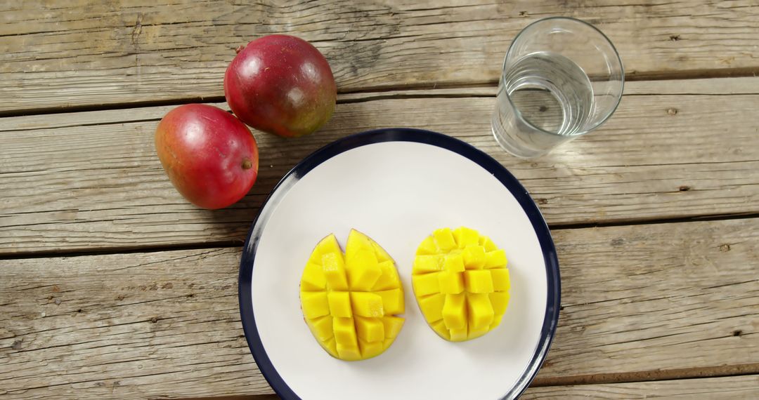 Sliced Mangoes on Plate with Whole Mangoes and Water Glass - Free Images, Stock Photos and Pictures on Pikwizard.com