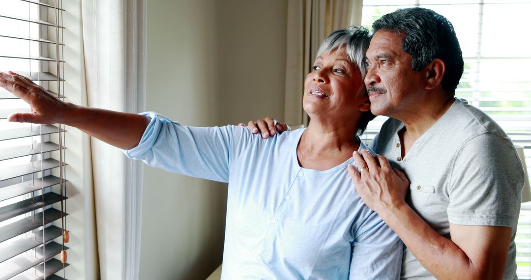 Middle-Aged Couple Contemplating by Window at Home