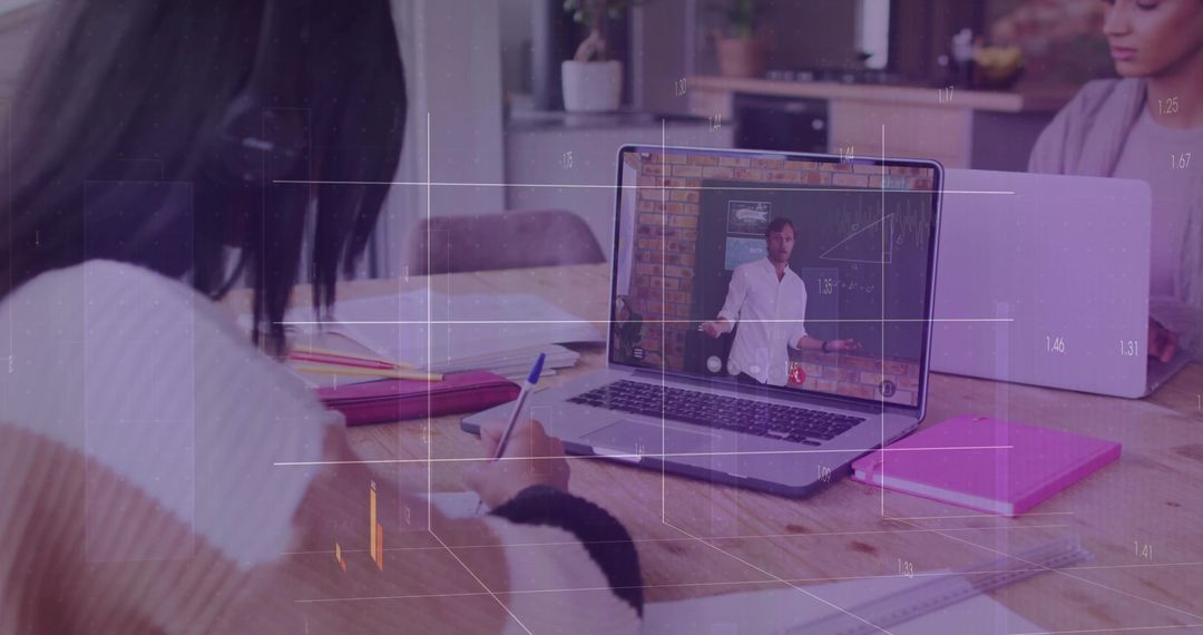 Teen Student Taking Notes from Educational Video in Kitchen