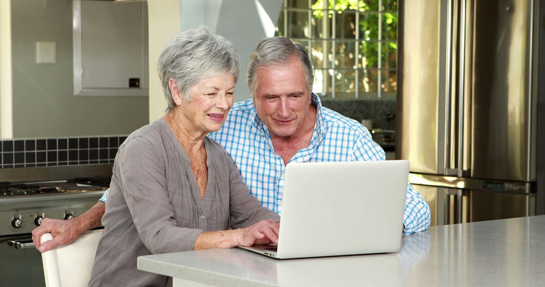 Happy Senior Couple Using Laptop at Modern Kitchen Counter - Free Images, Stock Photos and Pictures on Pikwizard.com