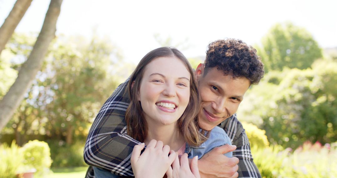 Joyful Multicultural Couple Embracing in Sunlit Garden