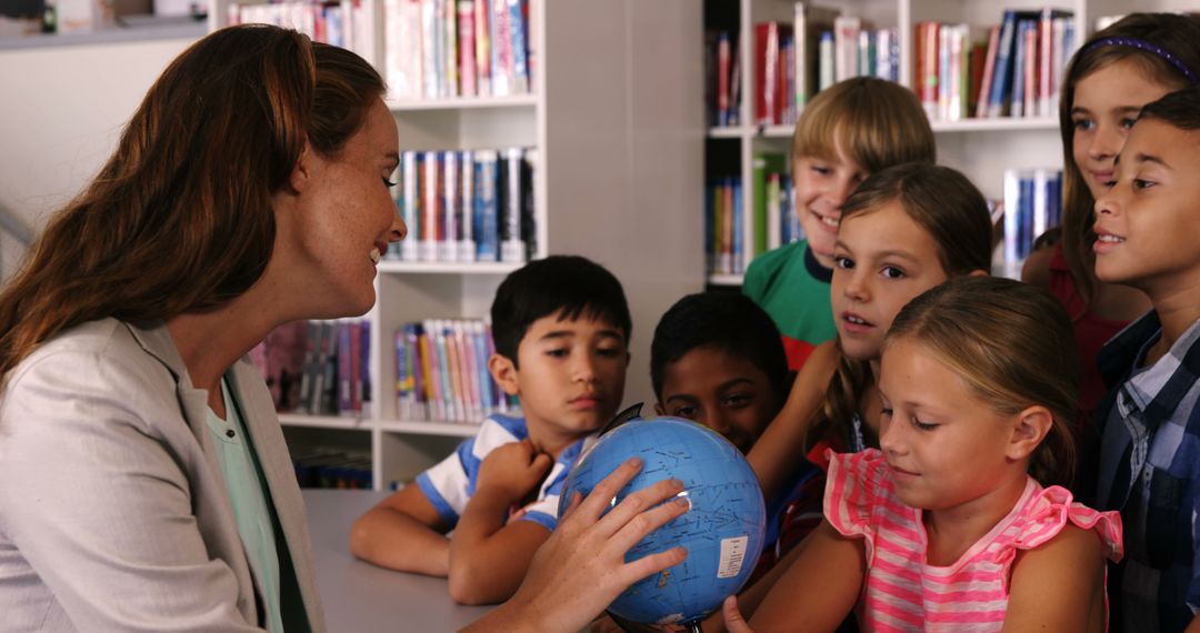 Teacher Engaging Students with Globe in Library Setting - Free Images, Stock Photos and Pictures on Pikwizard.com