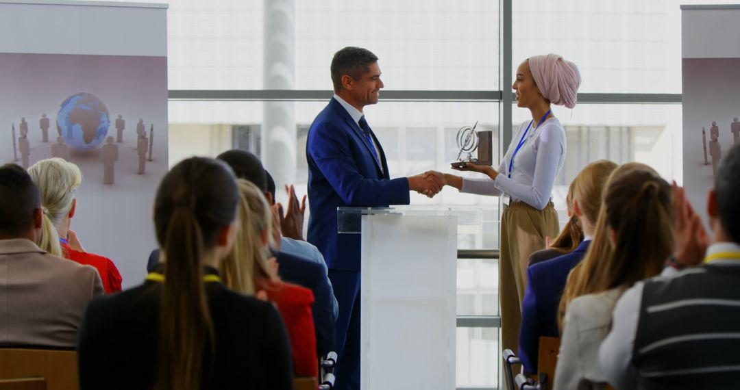 Businessman Awarding Trophy to Female Colleague at Corporate Ceremony - Free Images, Stock Photos and Pictures on Pikwizard.com