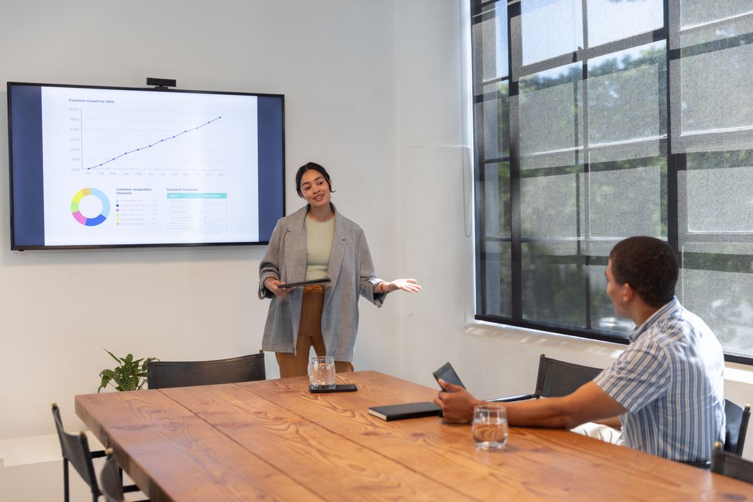 Diverse Coworkers Analyzing Data in Modern Office Presentation