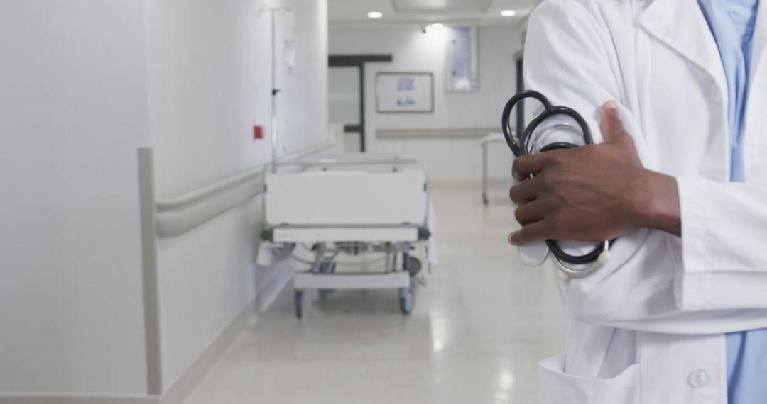 Doctor Holding Stethoscope in Modern Hospital Hallway - Free Images, Stock Photos and Pictures on Pikwizard.com