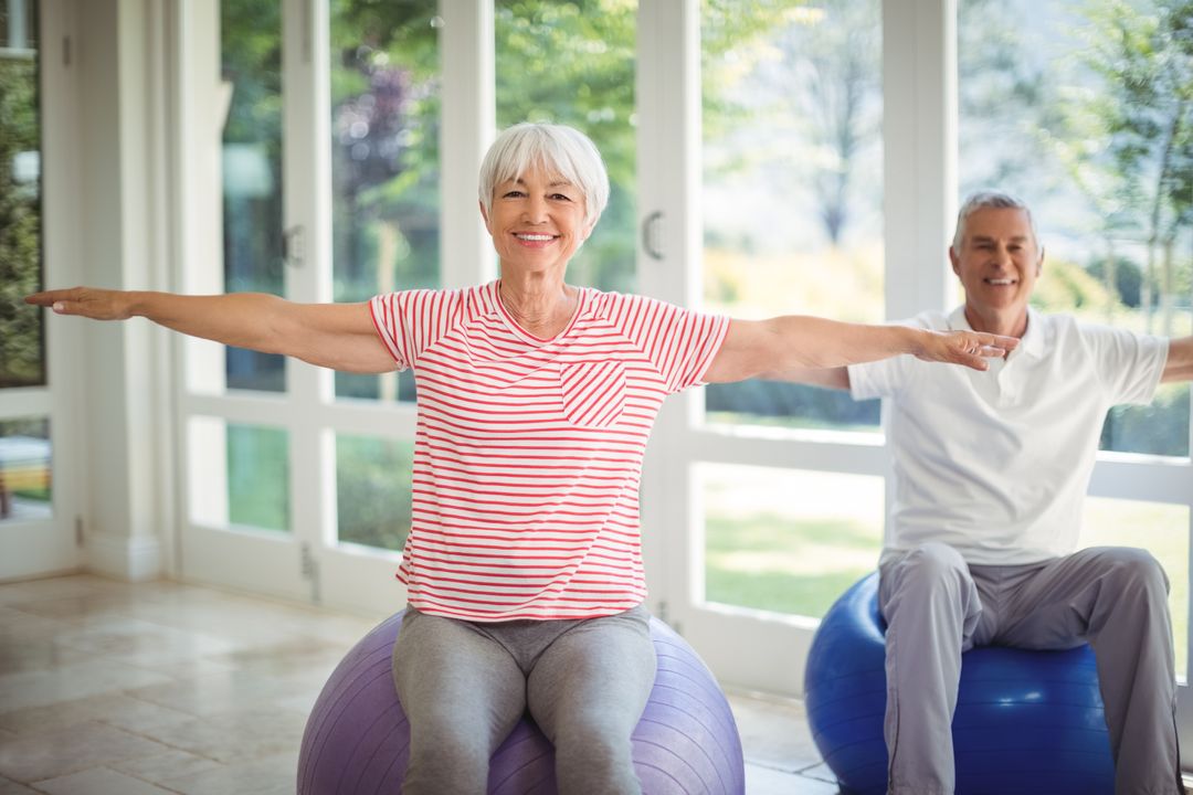 Senior couple performing stretching exercise on fitness ball - Free Images, Stock Photos and Pictures on Pikwizard.com