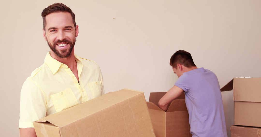 Young Men Moving Into New Home With Cardboard Boxes - Free Images, Stock Photos and Pictures on Pikwizard.com