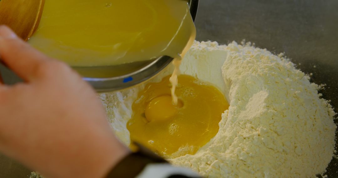 Hands Pouring Liquid Ingredients into Flour for Baking - Free Images, Stock Photos and Pictures on Pikwizard.com