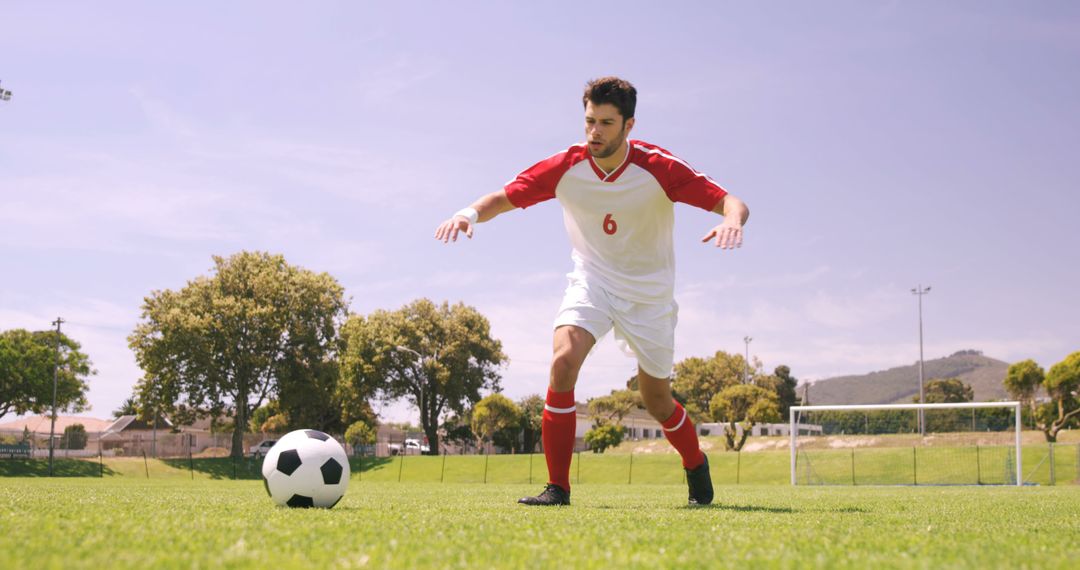 Soccer Player Focused on Ball During Training Session in Sunny Park - Free Images, Stock Photos and Pictures on Pikwizard.com