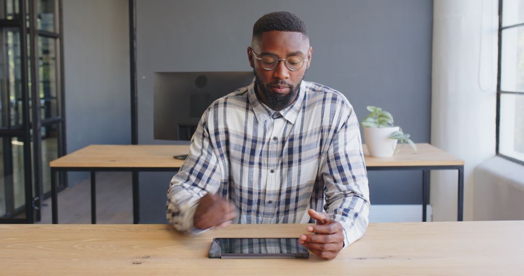 Businessman Strategizing with Tablet in Modern Office Workspace