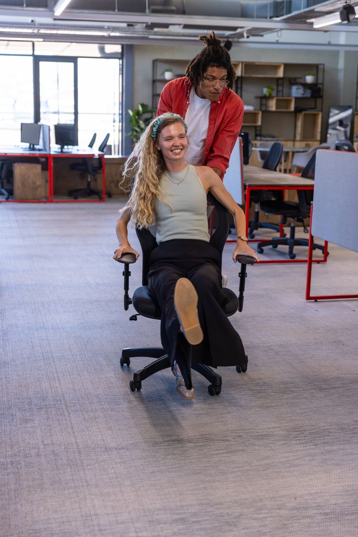 Diverse Coworkers Enjoying Exciting Office Chair Race