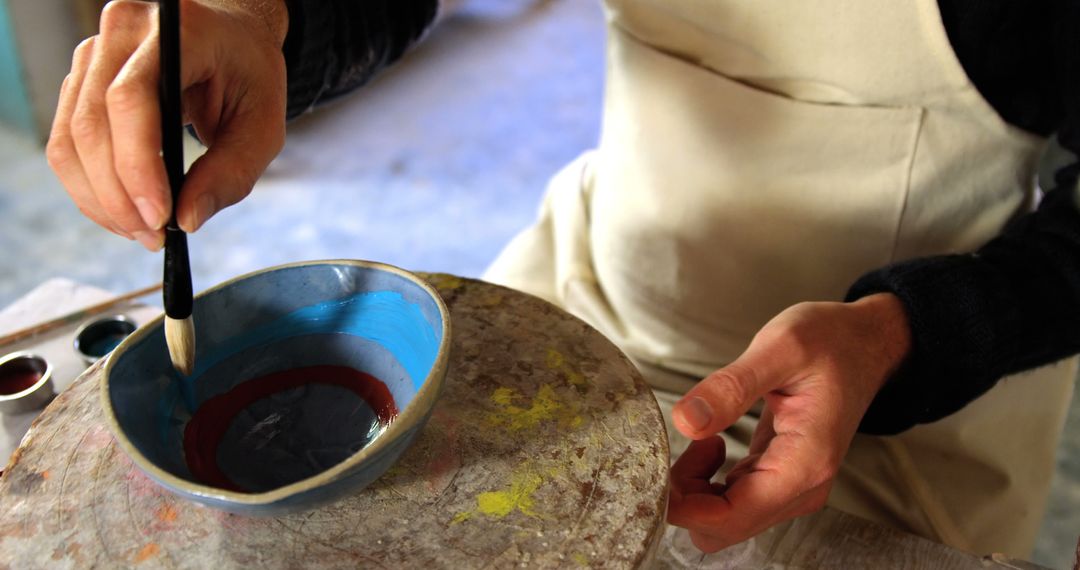 Person Painting Ceramic Bowl by Hand in Cozy Art Studio - Free Images, Stock Photos and Pictures on Pikwizard.com