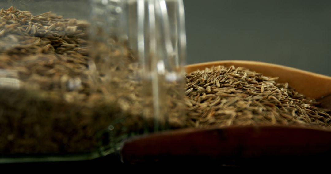 Close-Up of Cumin Seeds Spilling from Glass Jar into Bowl - Free Images, Stock Photos and Pictures on Pikwizard.com