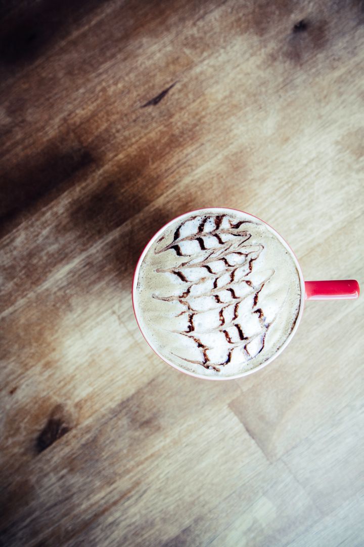 Top View of Latte with Intricate Foam Art on Wooden Table - Free Images, Stock Photos and Pictures on Pikwizard.com