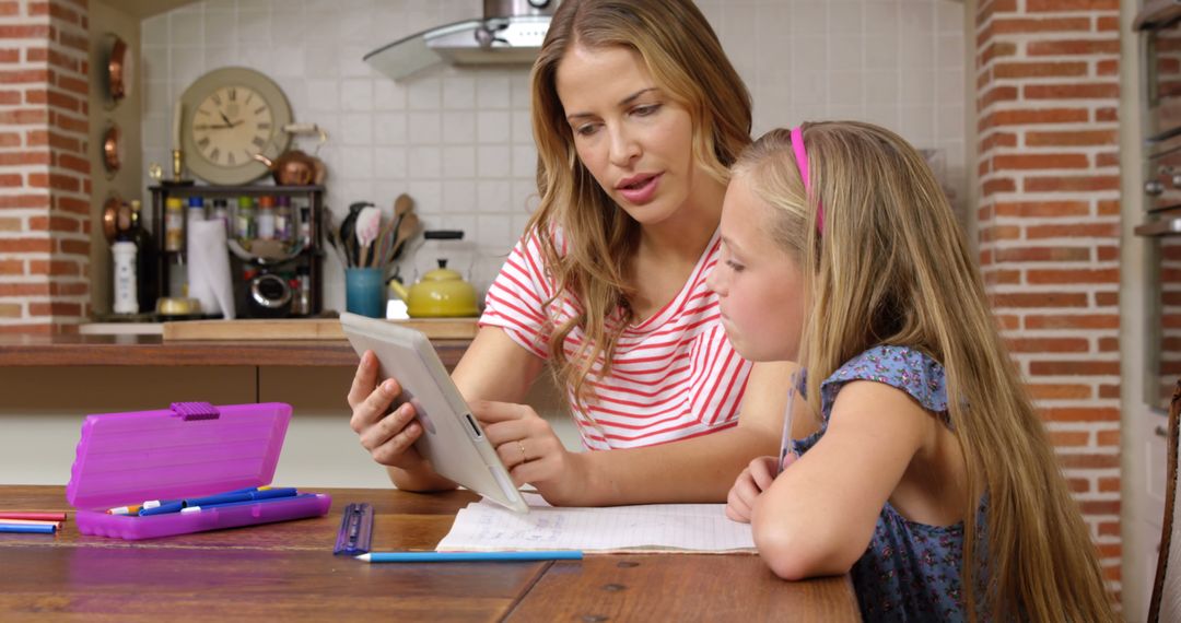 Mother and Daughter Using Tablet for Homework in Kitchen - Free Images, Stock Photos and Pictures on Pikwizard.com