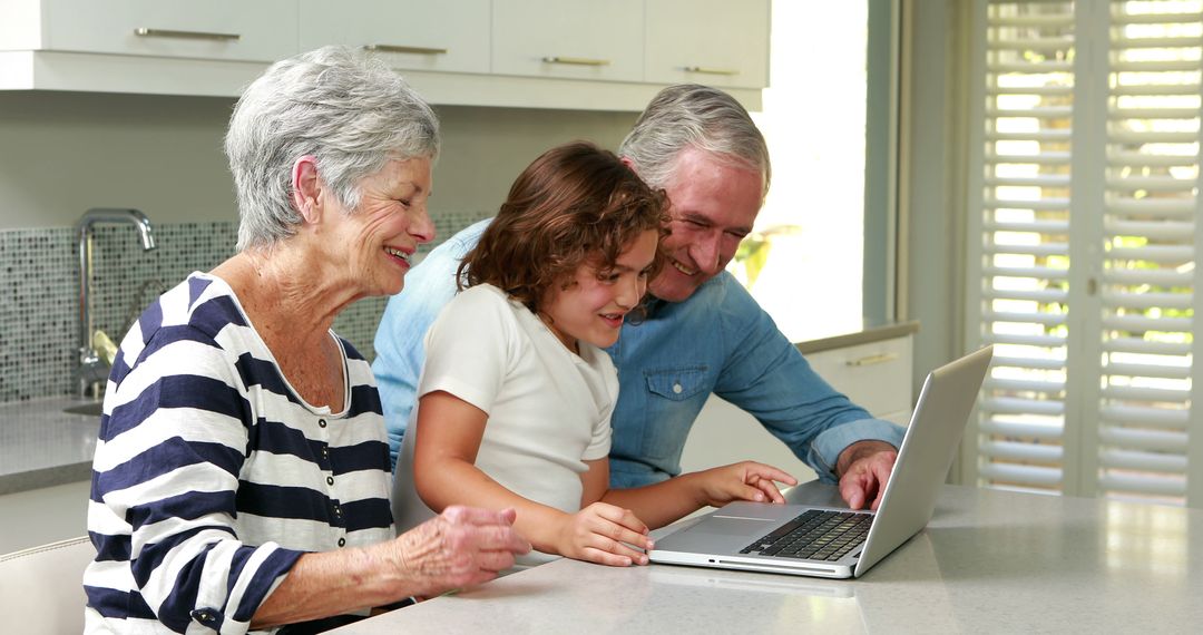 Happy Grandparents Teaching Grandchild to Use Laptop in Kitchen - Free Images, Stock Photos and Pictures on Pikwizard.com