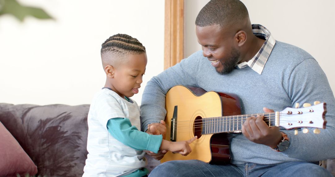 Father Teaching Son to Play Guitar at Home - Free Images, Stock Photos and Pictures on Pikwizard.com