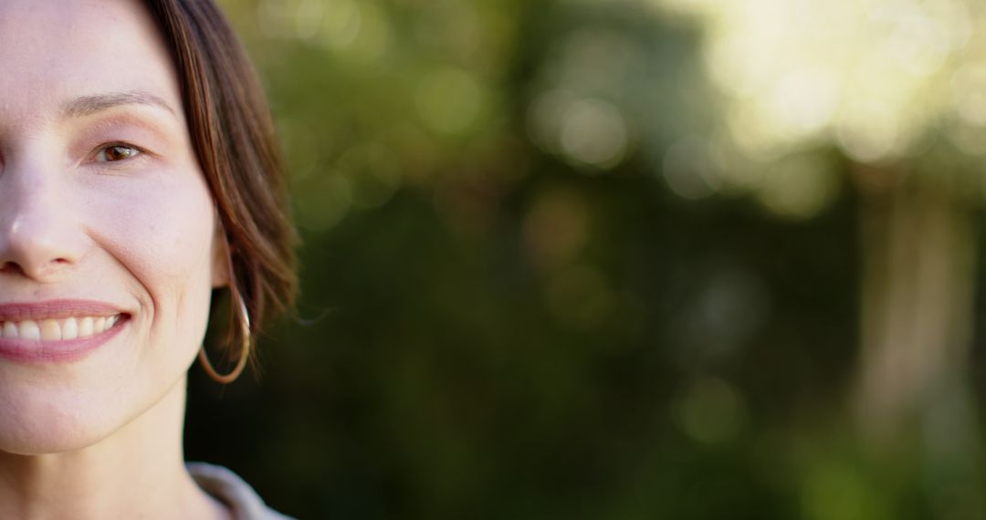 Smiling Woman Displaying Hoop Earring Amidst Tranquil Garden