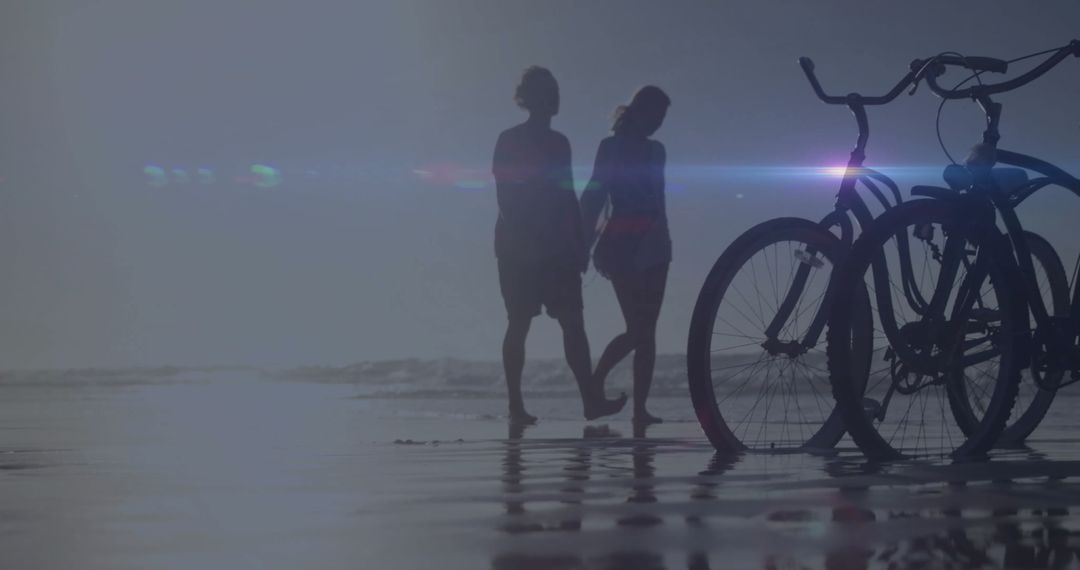 Couple Walking Hand in Hand on Beach with Bicycles
