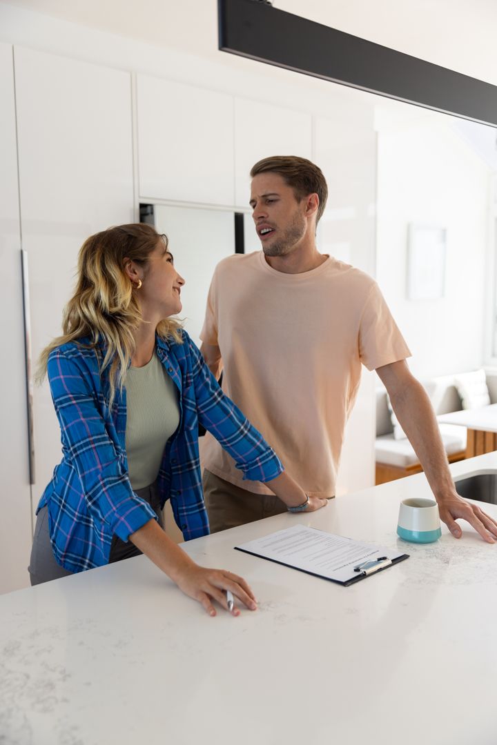 Couple Collaborating in Modern Kitchen Over Documentation