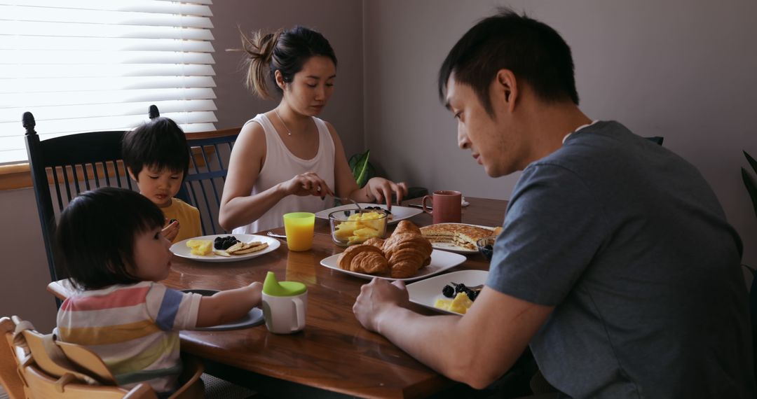 Asian Family Having Breakfast Together Around Dining Table - Free Images, Stock Photos and Pictures on Pikwizard.com