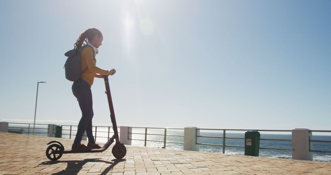 Young Woman Riding Electric Scooter on Sunny Coastal Path - Free Images, Stock Photos and Pictures on Pikwizard.com