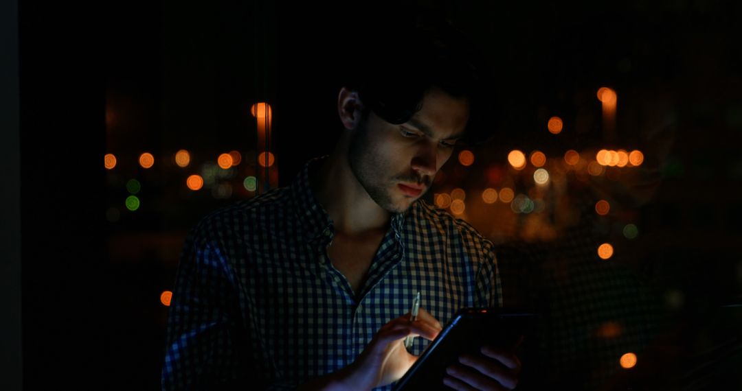 Young Caucasian Man Checking Phone at Night with City Lights in Background - Free Images, Stock Photos and Pictures on Pikwizard.com