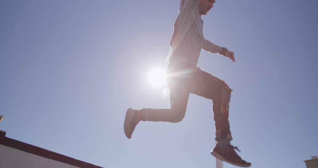 Young Man Jumping with Blue Sky Background and Sunshine - Free Images, Stock Photos and Pictures on Pikwizard.com