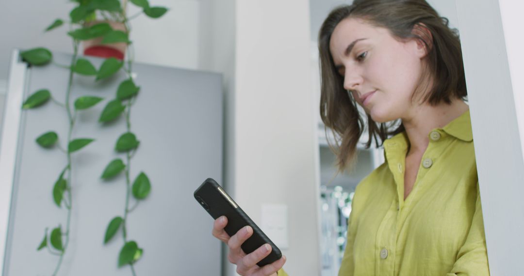 Caucasian woman wearing yellow shirt and using smartphone - Free Images, Stock Photos and Pictures on Pikwizard.com