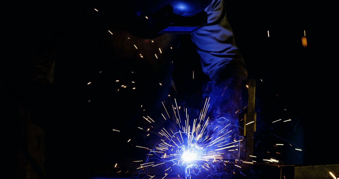 Welder Working with Sparks Flying in Dark Workshop - Free Images, Stock Photos and Pictures on Pikwizard.com