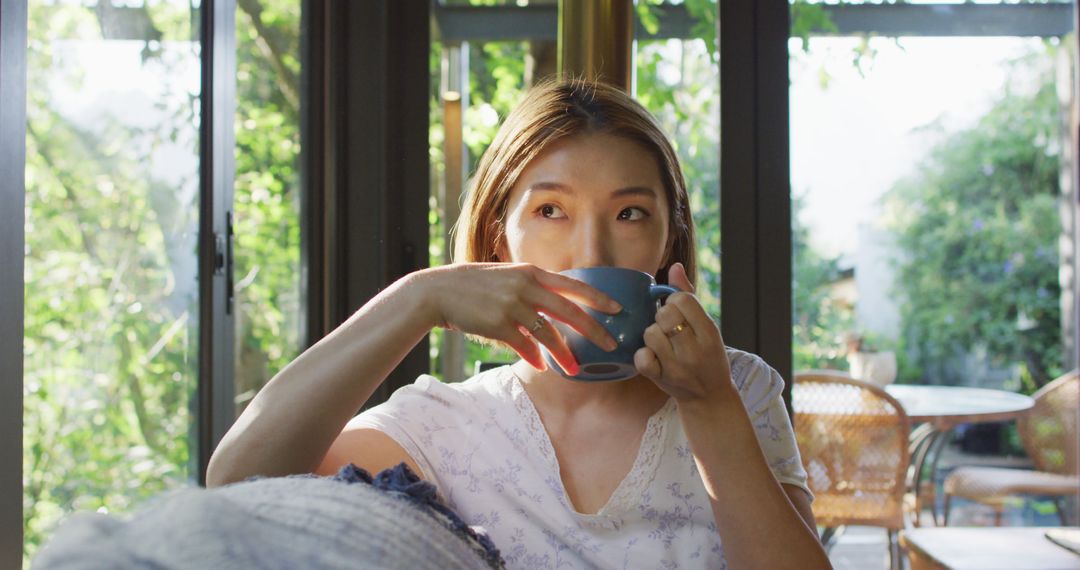 Woman Relaxing Indoors Enjoying Morning Coffee Near Window - Free Images, Stock Photos and Pictures on Pikwizard.com