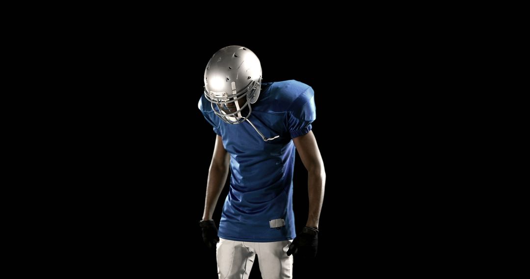 American football player in uniform isolated against black background - Free Images, Stock Photos and Pictures on Pikwizard.com