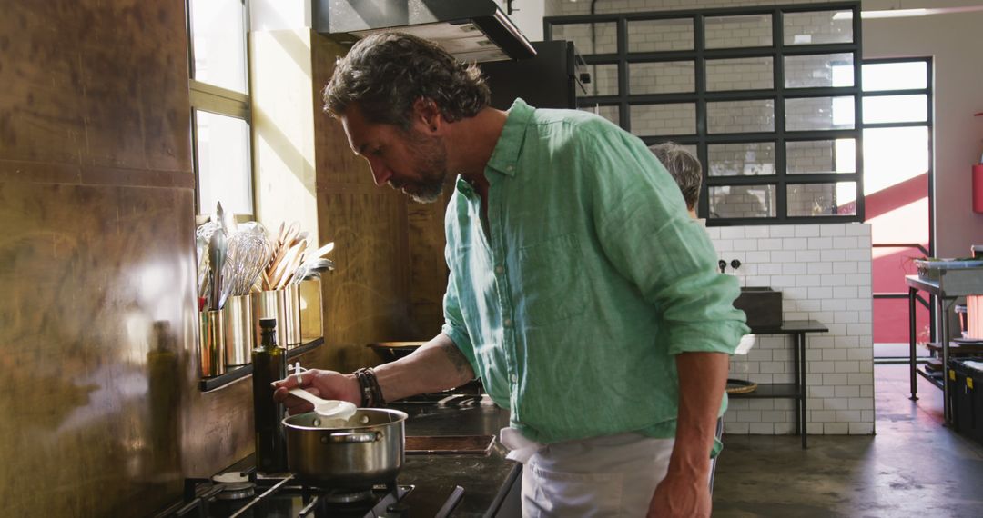 Senior Caucasian Man Enthusiastically Cooking in Sunlit Kitchen - Free Images, Stock Photos and Pictures on Pikwizard.com