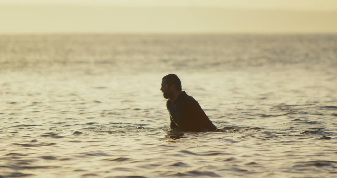 Solitary Man Wading in Calm Ocean Waters at Sunset - Free Images, Stock Photos and Pictures on Pikwizard.com