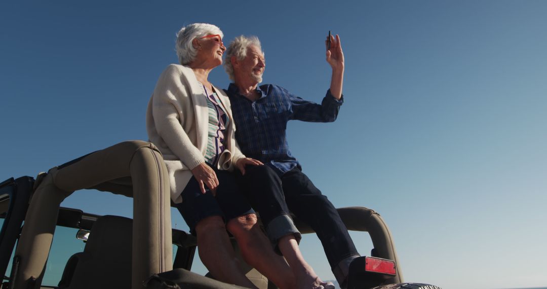 Senior couple enjoying road trip waving from car rooftop - Free Images, Stock Photos and Pictures on Pikwizard.com