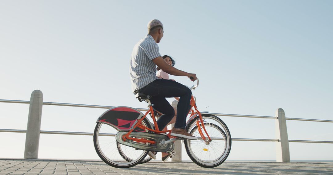 Man and Woman Riding Bicycle on Seaside Promenade on Sunny Day - Free Images, Stock Photos and Pictures on Pikwizard.com