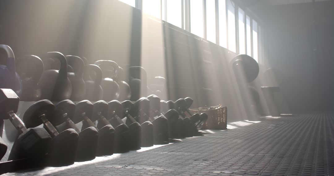 Sunlight Illuminating Kettlebells and Dumbbells in Modern Gym