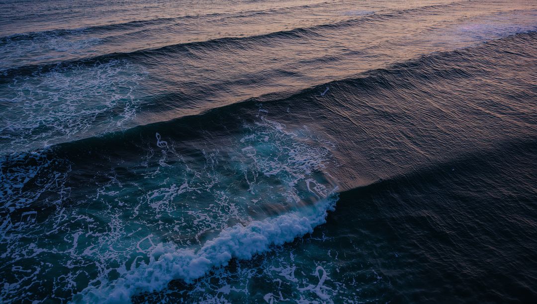 Rolling Parallel Ocean Waves with White Sea Foam at Sunset