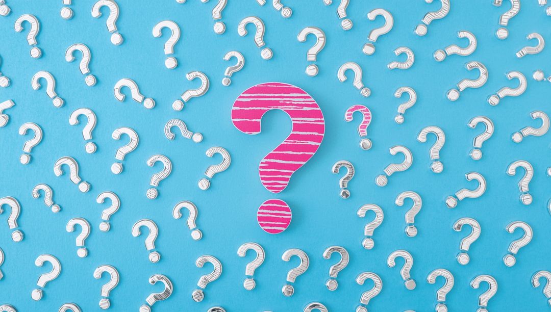 Question Mark Cutouts on Blue Background Highlight One in Pink